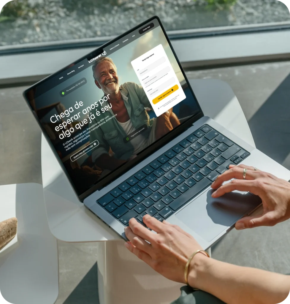 Laptop com tela exibindo login do banco digital LG Bank e homem sorrindo.